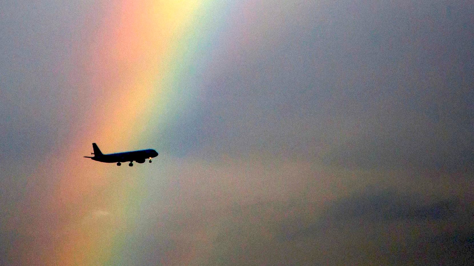 An American Airlines flight passes in front of partial rainbow on approach to landing at Dallas/Fort Worth International Airport on Tuesday, Oct. 3, 2017. 