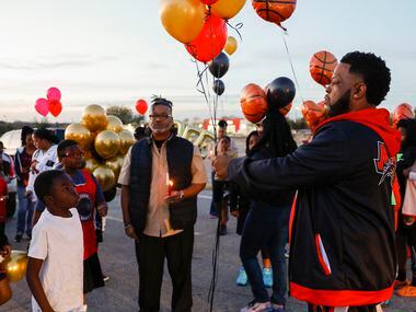 Coach Lo Williams hands out balloons before a balloon release in memory of 11-year-old...