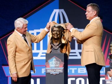 Pro Football Hall of Fame inductee Jimmy Johnson of the Dallas Cowboys (left) unveils his bronze bust with presenter and former Cowboy Troy Aikman during the Centennial Class of 2020 enshrinement  ceremony at Tom Benson Hall of Fame Stadium in Canton, Ohio, Saturday, August 7, 2021. (Tom Fox/The Dallas Morning News)