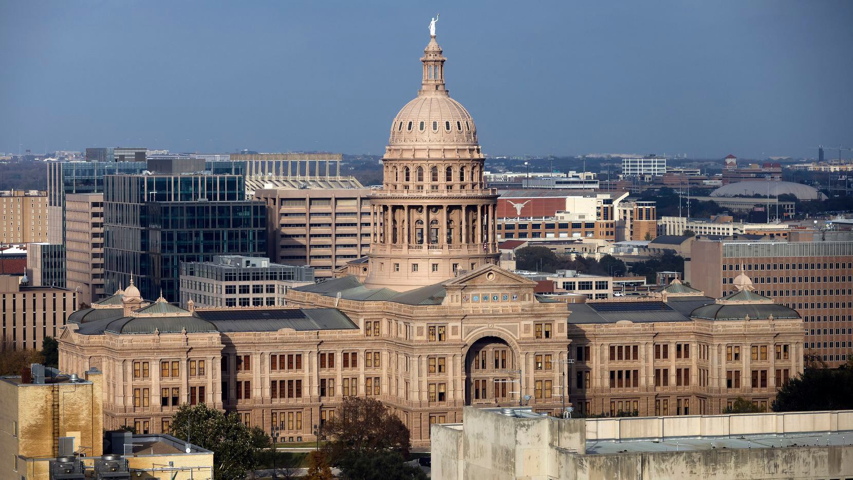 The Texas State Capitol is surrounded by buildings and the University of Texas in Austin,...