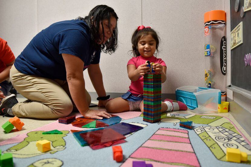 Patricia Vega works with her daughter Elizabeth Diaz, 3, on educational activities to help...
