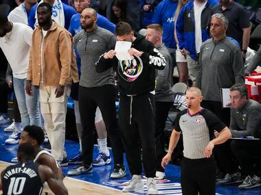 Dallas Mavericks guard Luka Doncic covers his face with a piece of paper after a missed...