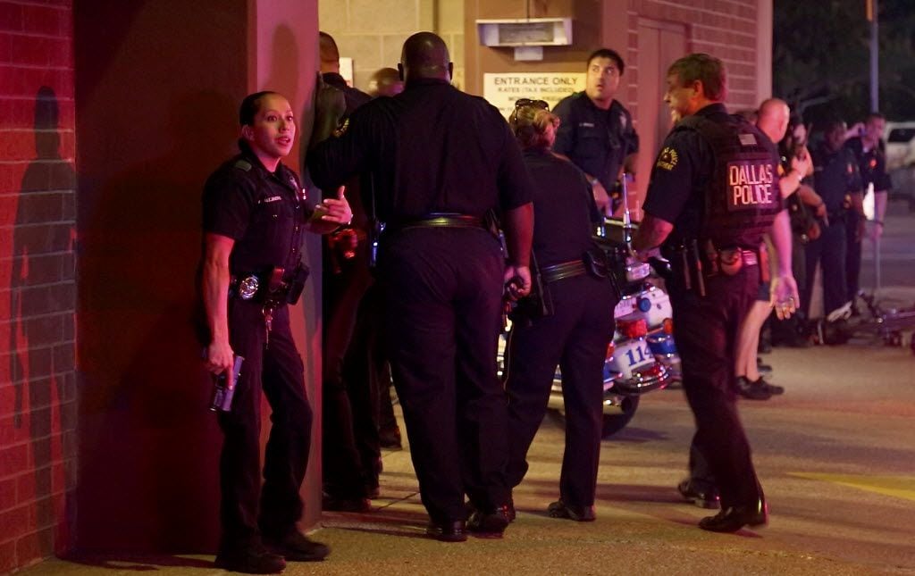 **VIDEO FRAME GRAB** Dallas Police officers stand near the entrance of a parking structure...