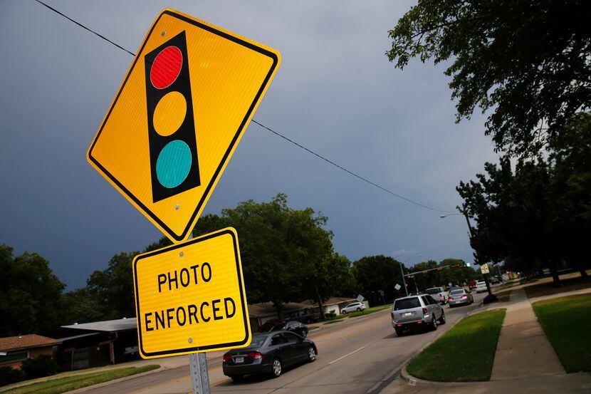 A sign warns drivers of Irving's use of red-light cameras at O'Connor Road and Lane Street...