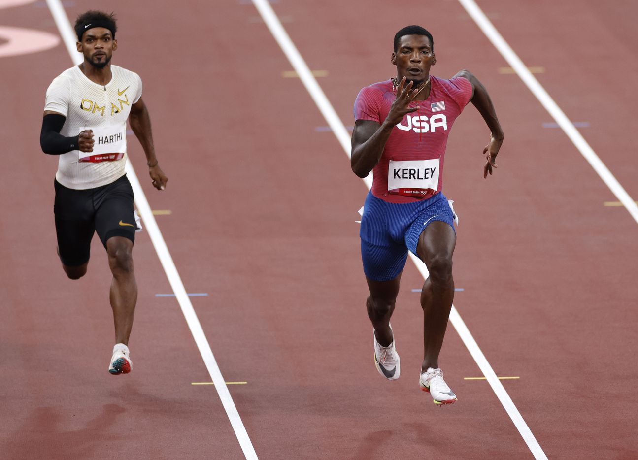 USA’s Fred Kerley (right) and Barakat Al Harthi (left) race to the finish in heat 5 of 7...