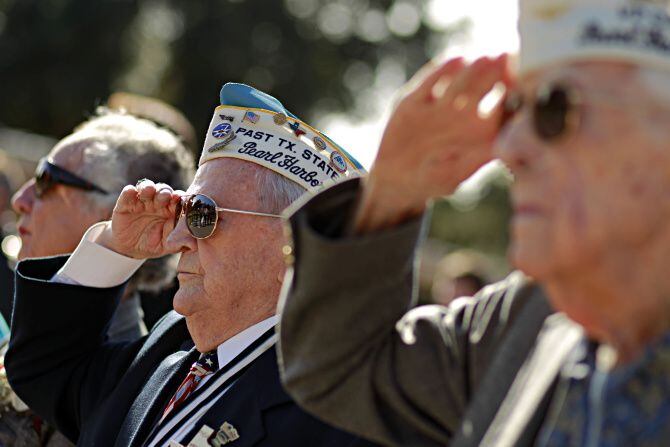 Pearl Harbor survivor Robert Tanner (second from left), saluted the flag during the Pledge...