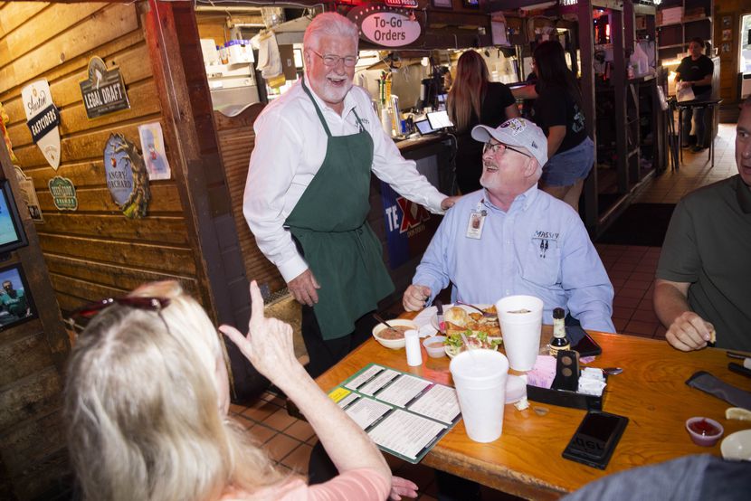 (From center left) Randy Ford, president and owner of J.Gilligan's Bar and Grill, puts a...