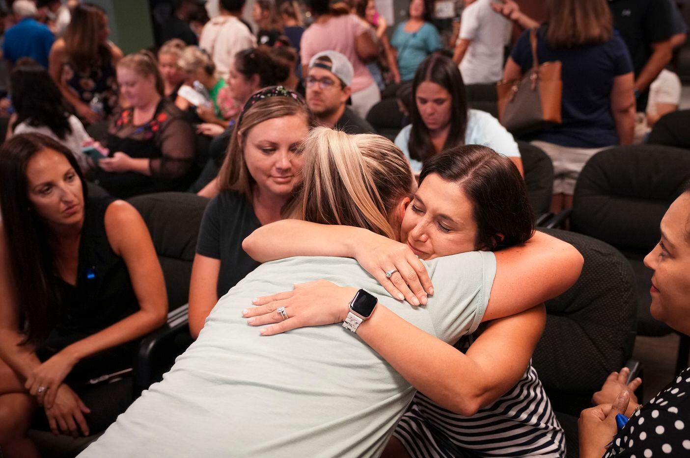 Lisa Cox (facing) gets a hug of support after speaking during public comment in a Prosper...