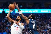 LA Clippers forward Paul George (13) scores as he is fouled by Dallas Mavericks guard Kyrie...