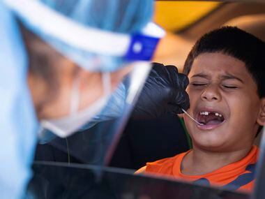Elizabeth Osborn, medical assistant at WellHealth, swabs Josiah Soto's (4) mouth for COVID...