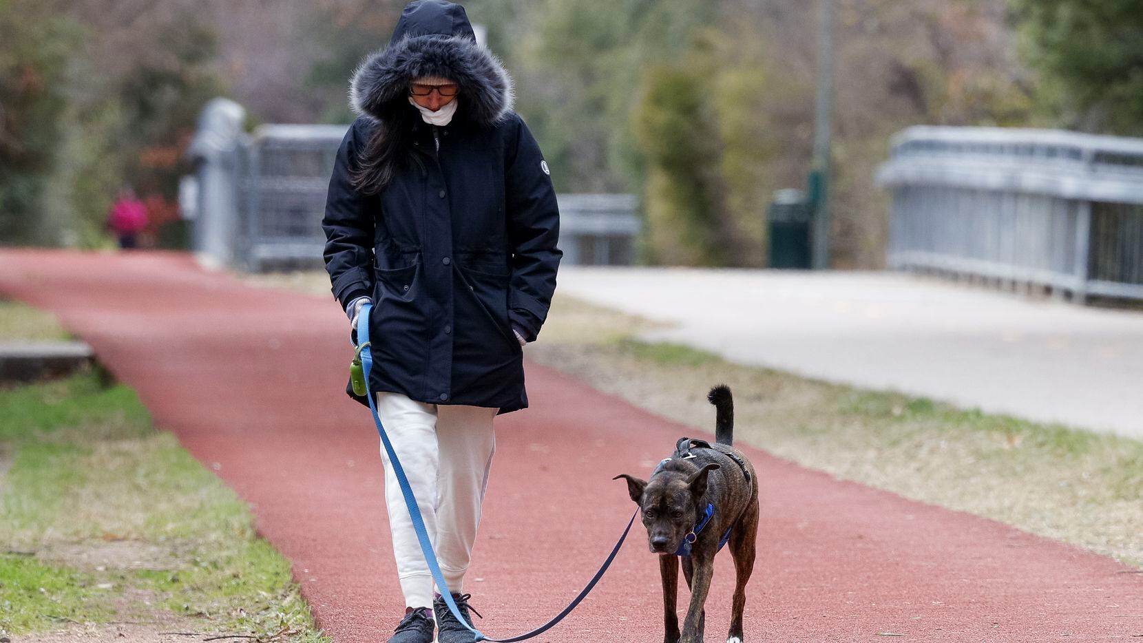 Sarah Capeloutl, 29, walks with her dog Addie along the Katy Trail in Dallas.