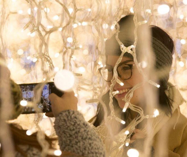 Visitors take pictures among the Christmas lights at Enchant Christmas at Globe Life Park in...