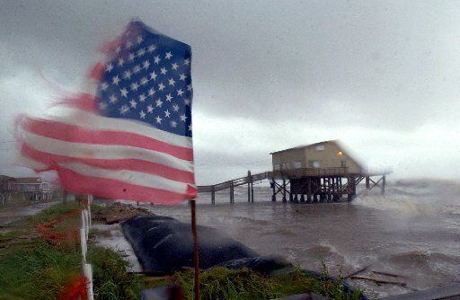  The wind whips a a U.S. flag in the neighborhood of Treasure Inland in San Luis Pass,...