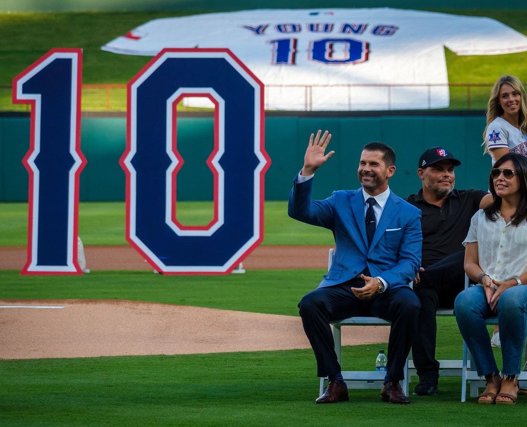 Michael Young waves to the crowd during ceremonies to retire Young's No. 10 before a game...