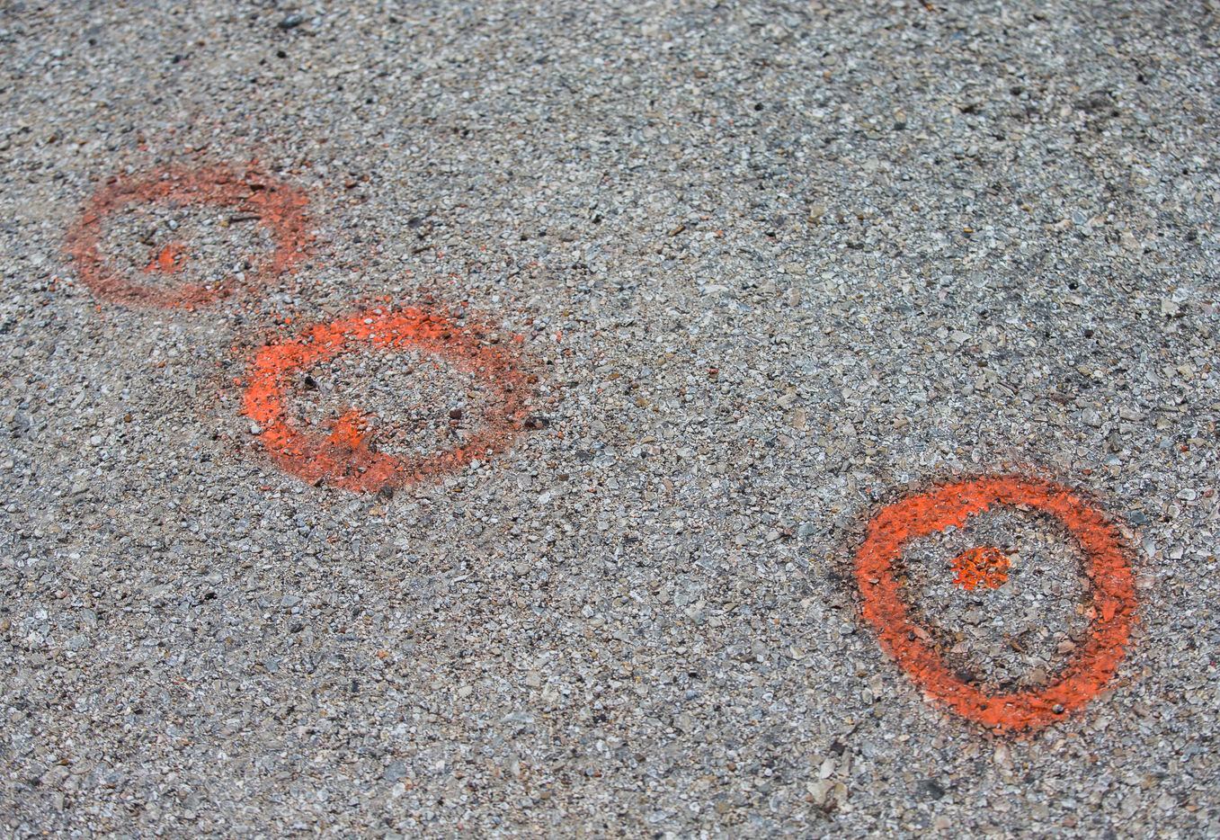 Orange spray painted circles mark the location where four shell casings were found.