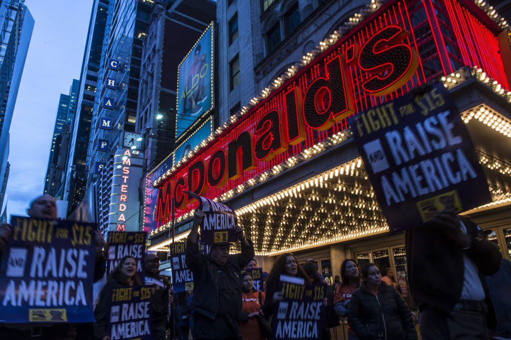 Demonstrators in support of raising minimum wage march outside a McDonald's restaurant in...