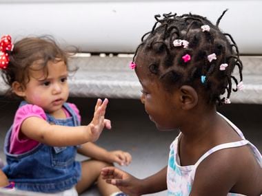 Daniela Martinez, 1, left, and Louvenjuna Elien, 4, try on makeup at Senda de Vida shelter...