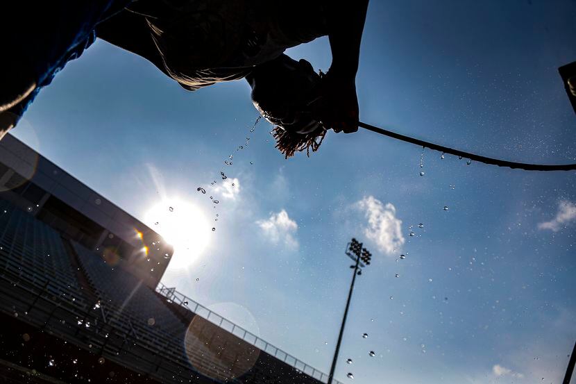 Wilmer-Hutchins sophomore safety Kindrich Smith drinks from the water cart during a break in...