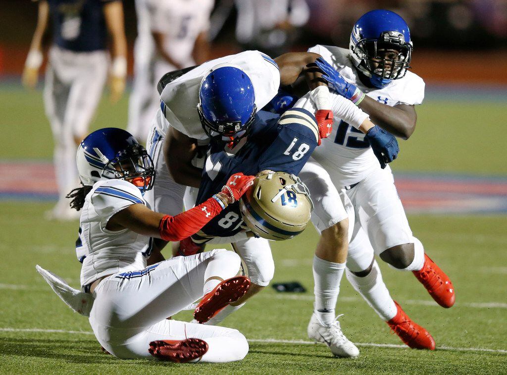 Austin Regents John Roberts (81) is tackled by Trinity Christian's Cam'Ron Silmon (12) Marques Buford (8) Makii Lewis (15) during the first half of play at the TAPPS Division II State Championship game at Waco Midway's Panther Stadium in Hewitt, Texas on Friday, December 6, 2019. (Vernon Bryant/The Dallas Morning News)