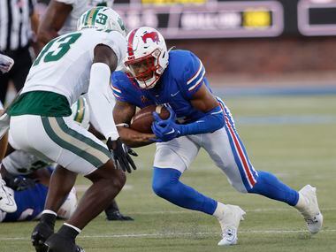 SMU running back Jaylan Knighton (4) carries the ball as Charlotte 49ers defensive back...