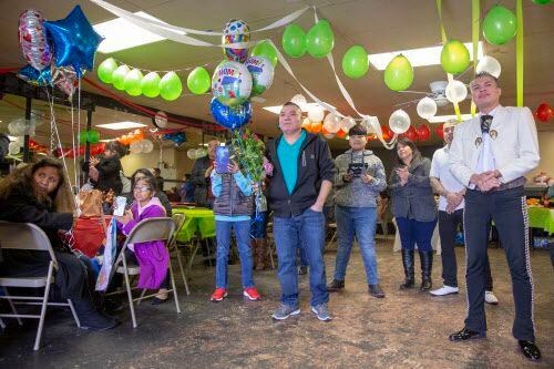 Familias esperan para ver a sus familiares con globos y flores , durante un evento de...