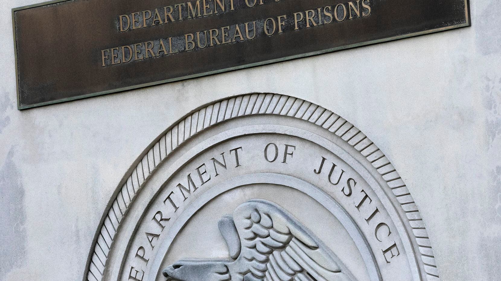 FILE - A sign for the Department of Justice Federal Bureau of Prisons is displayed at the...