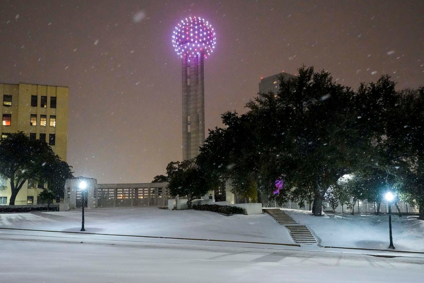 Snow falls on Dealy Plaza and Reunion Tower downtown as a winter storm brings snow and freezing temperatures to North Texas on Sunday, Feb. 14, 2021, in Dallas.