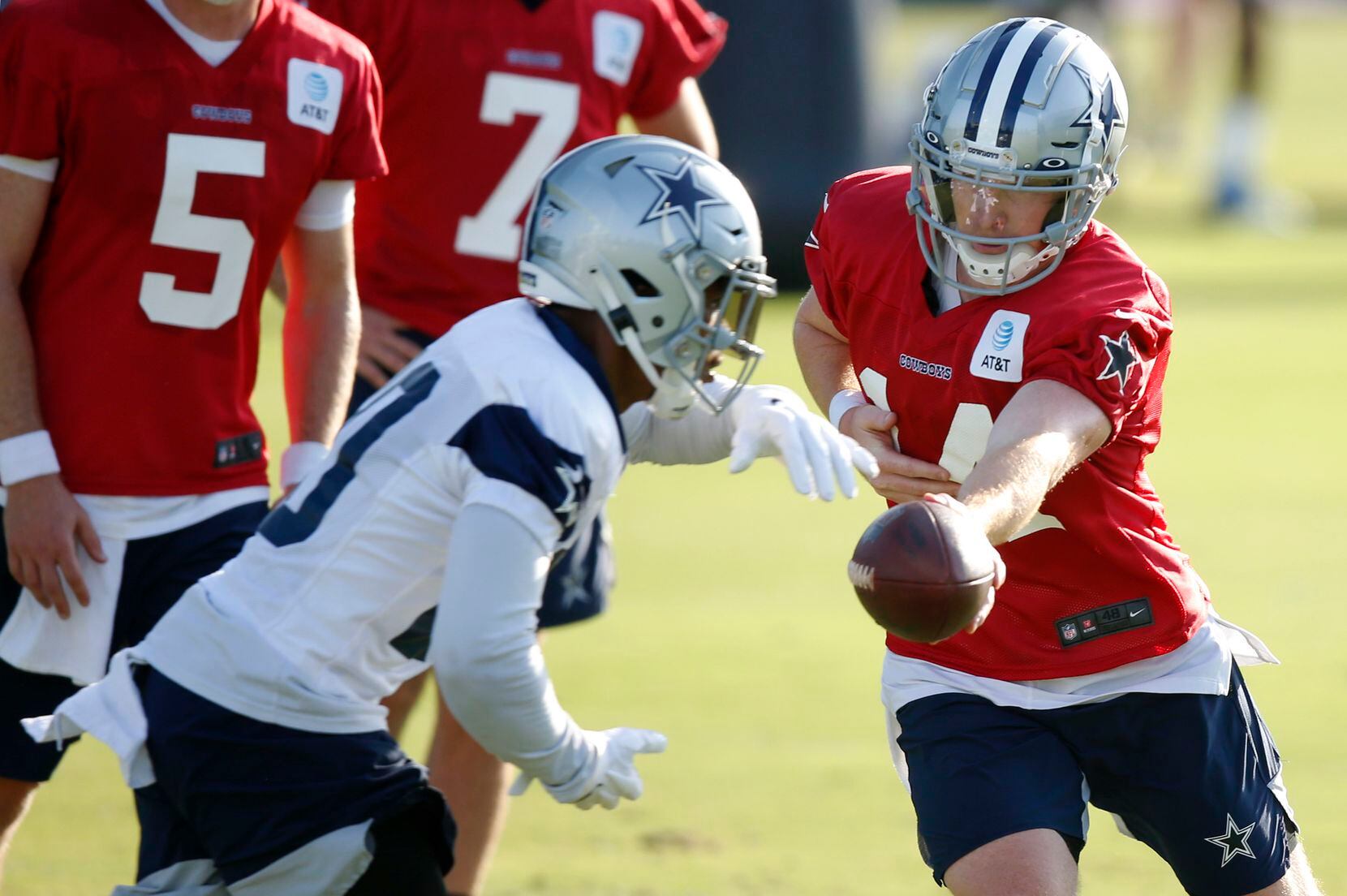 Dallas Cowboys quarterback Andy Dalton (14) hands the ball off to Dallas Cowboys running...