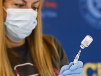 Nurse Kathryn Webb prepares an Influenza vaccine ahead of a press conference on bivalent...