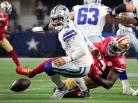 Dallas Cowboys quarterback Dak Prescott (4) fumbles as he is sacked by San Francisco 49ers defensive end Charles Omenihu (92) during the second half of an NFL Wild Card playoff football game at AT&T Stadium on Sunday, Jan. 16, 2022, in Arlington.