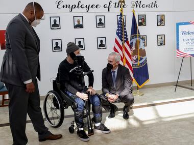 Veterans Secretary Denis McDonough (right) speaks with Army veteran John Caruso (center)...