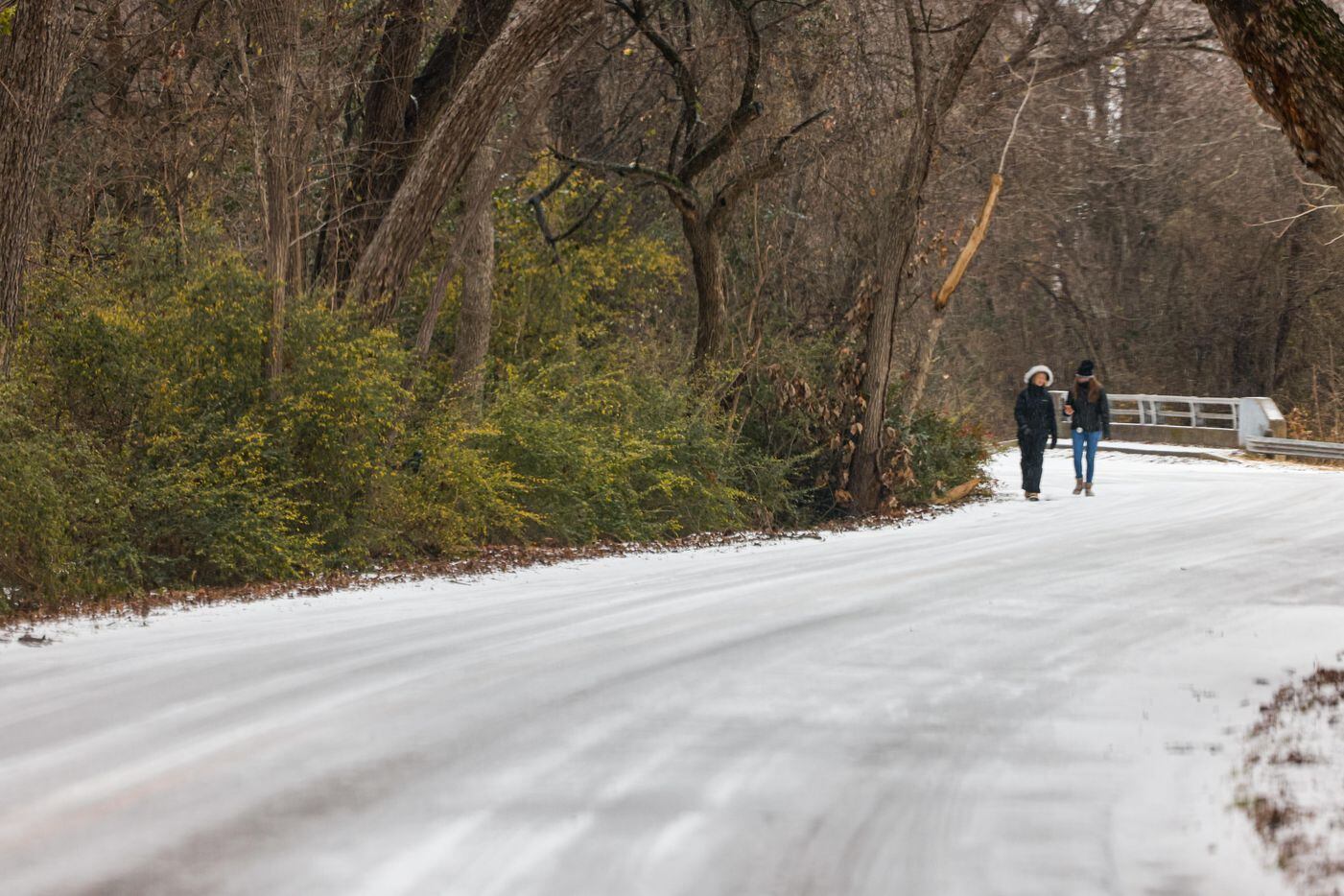 Two people walk on a street around White Rock Lake in Dallas on Thursday, February 3, 2022....