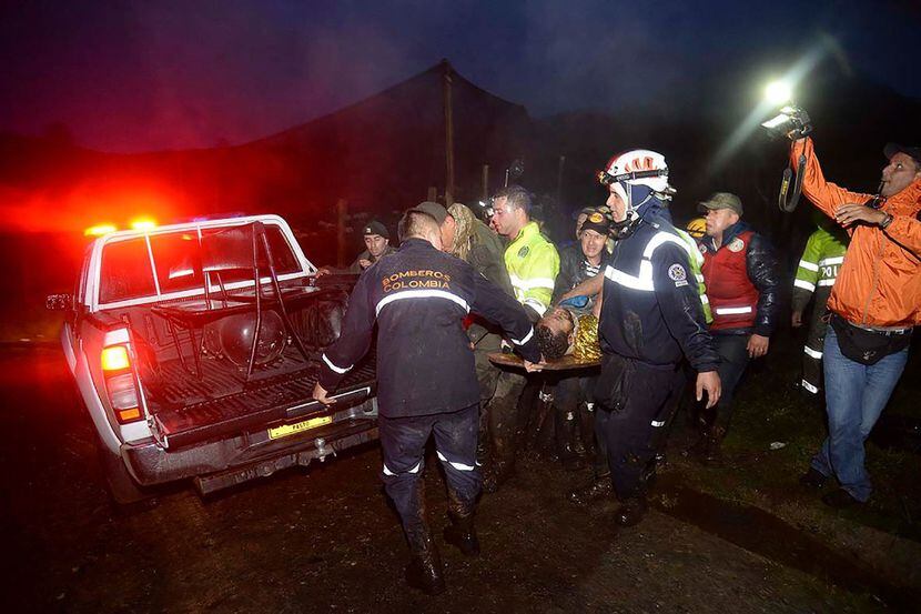 Socorristas llevan a uno de los supervivientes del avión charter LaMIa que rescata a uno de...