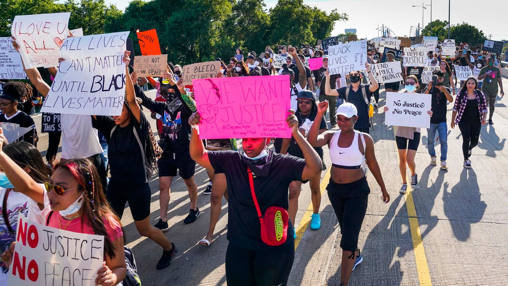 Demonstrators march on the Arapaho Road bridge crossing Midway Road during a protest on Thursday, June 4, 2020, in Addison. Protests continued Thursday in the response to the death of George Floyd.