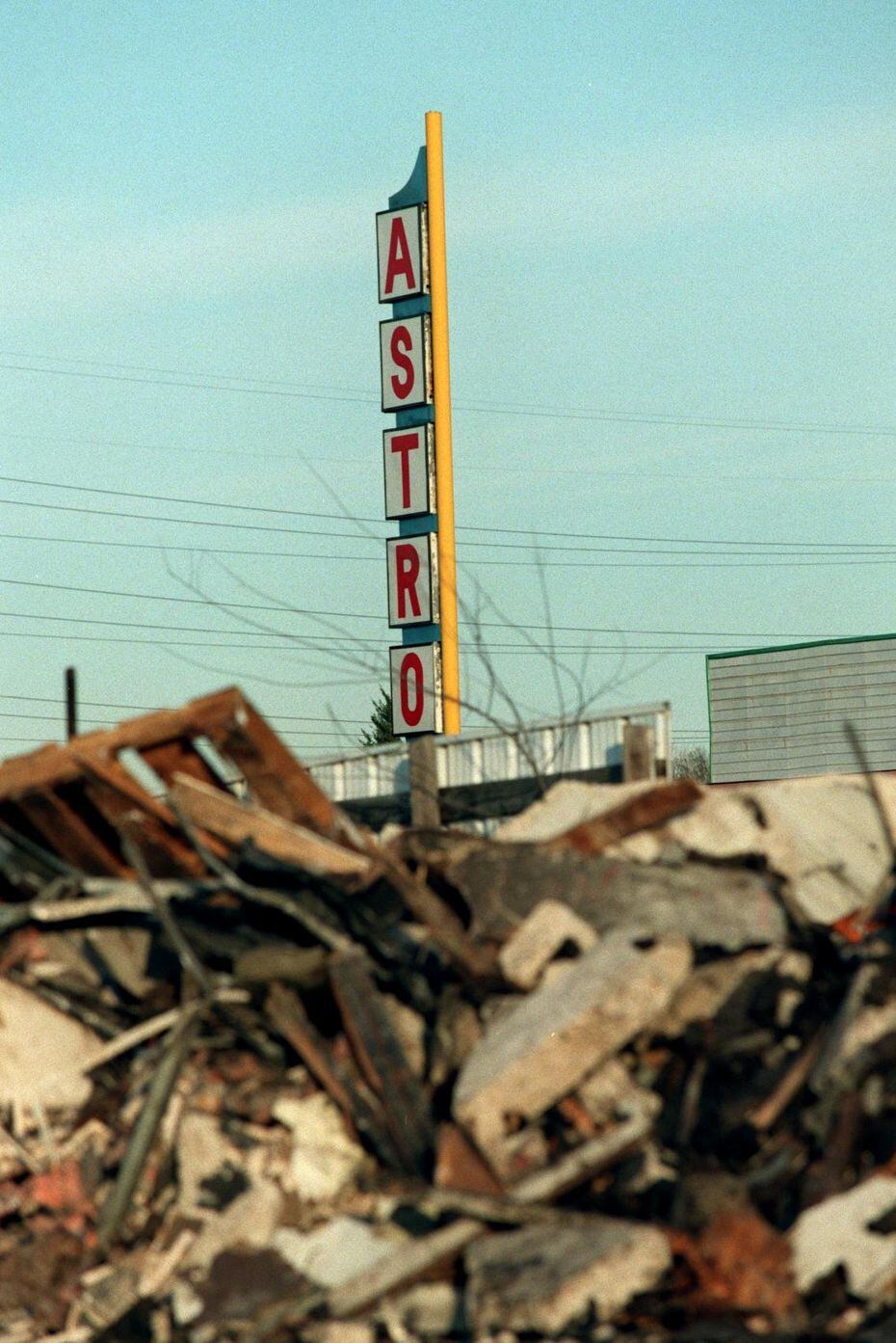 The Astro Drive-In sign towers over rubble  after the old drive-in movie theater was torn...