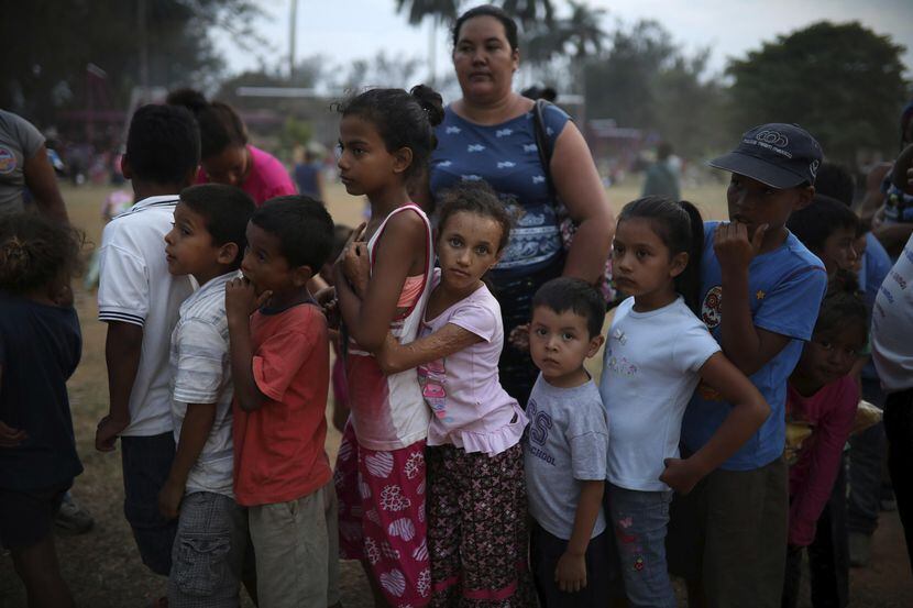 Niños se forman para recibir regalos en el campamento donde se encontraban esta semana...