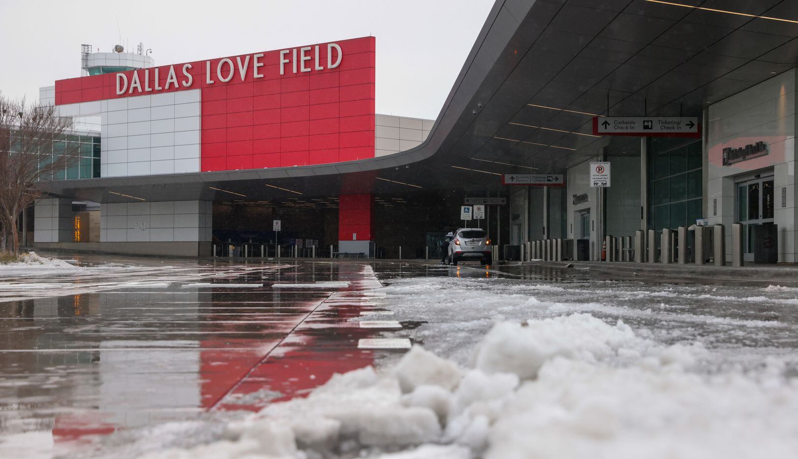 Ice sits along the curbside of Dallas Love Field Airport in Dallas on Wednesday, Feb. 1,...