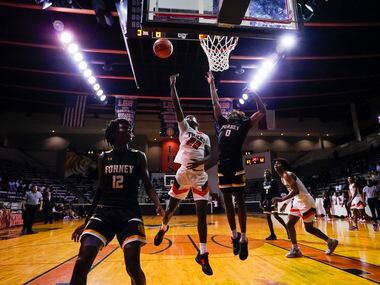 Lancaster's Jordan Williams (22) drives to the basket against Forney’s Ronnie Harrison (0)...