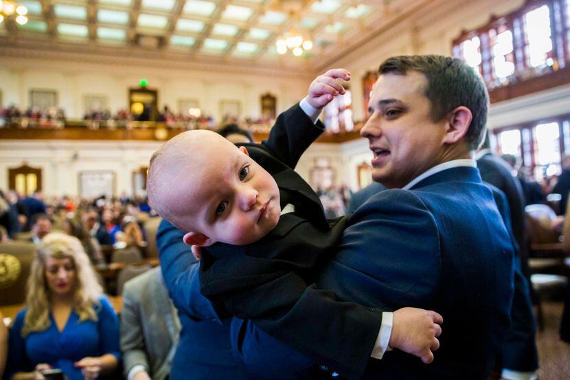 Texas State Representative Brisco Cain wrangles his son, Crockett Cain, 13 months, during...