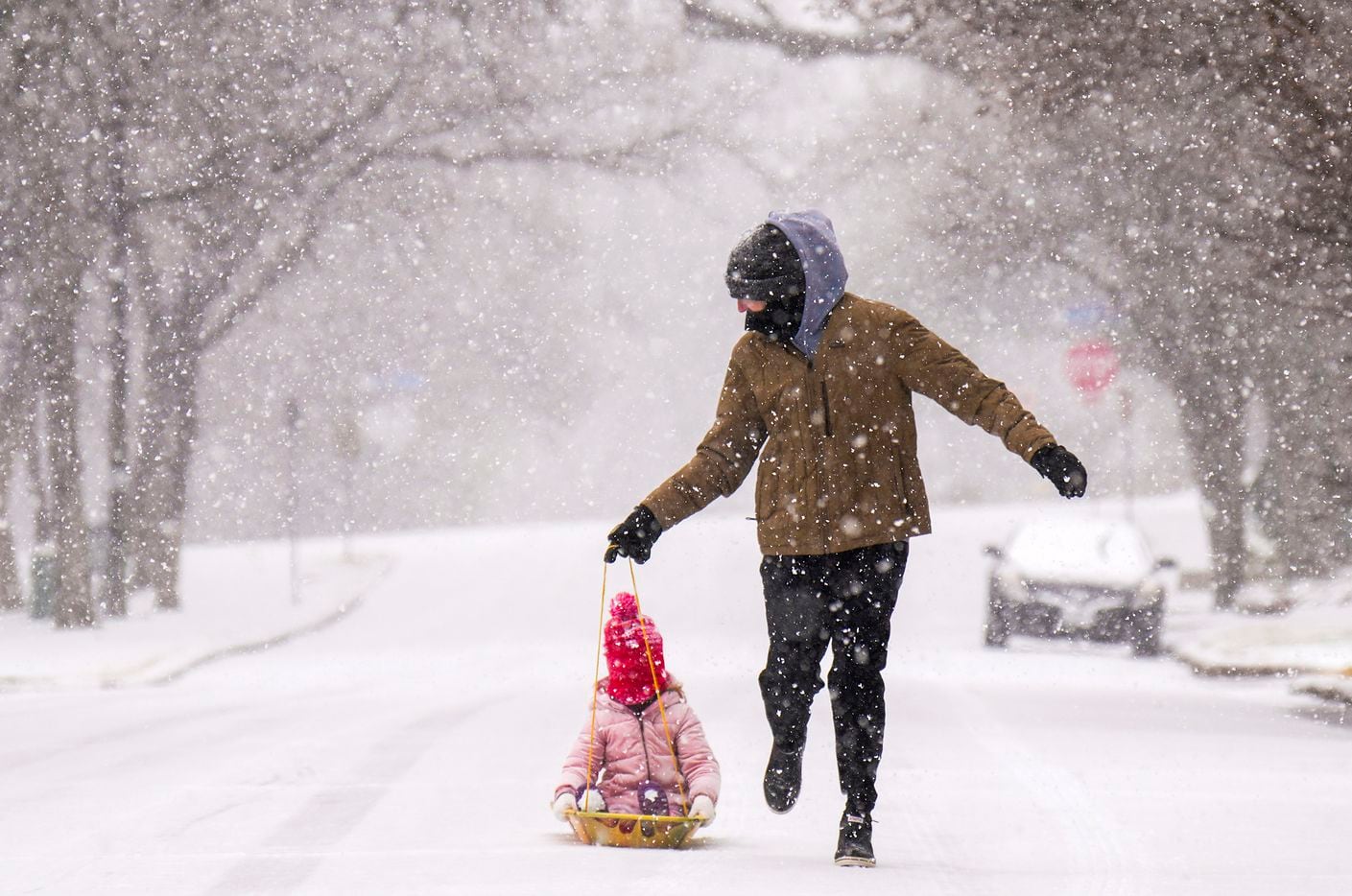 Josh Moore pulls his daughter Emma, 4, on a sled along West Prairie Creek Drive as a winter...