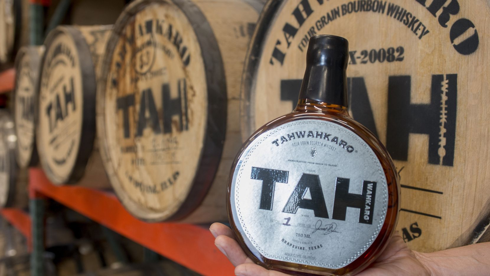 Chris Vivion holds a first-batch bottle of Tahwahkaro four-grain bourbon whiskey at the...