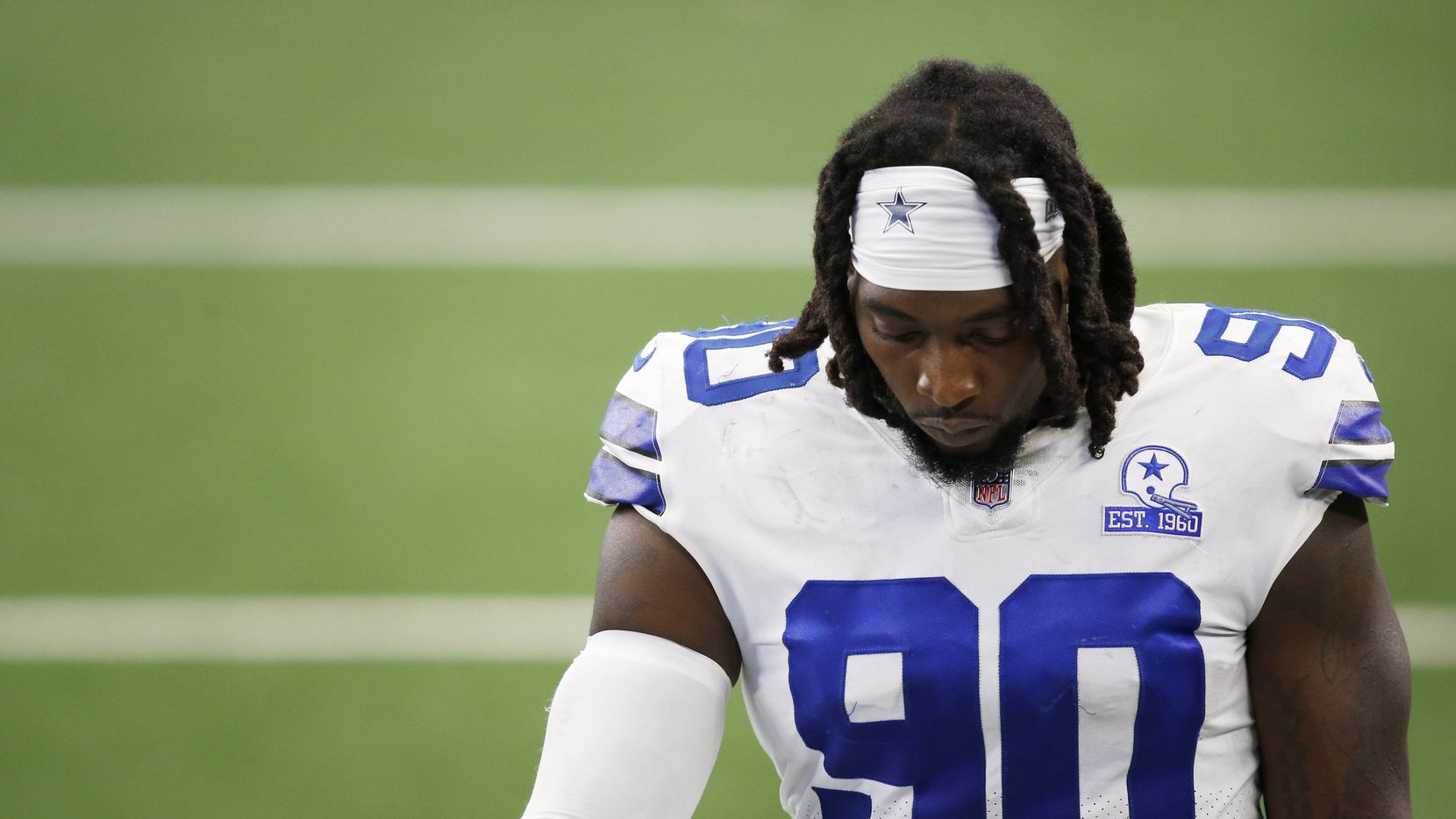 Dallas Cowboys defensive end DeMarcus Lawrence (90) makes his way off the field after losing...