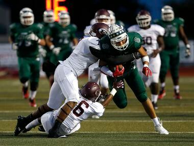 Ennis' Tori Williams (7) and Braylon Davis (16) tackle Waxahachie tight end Devan Brady (8) in the first quarter of the game between Waxahachie High School and Ennis High School at Lumpkins Stadium in Waxahachie, Texas on Sept. 11, 2015.