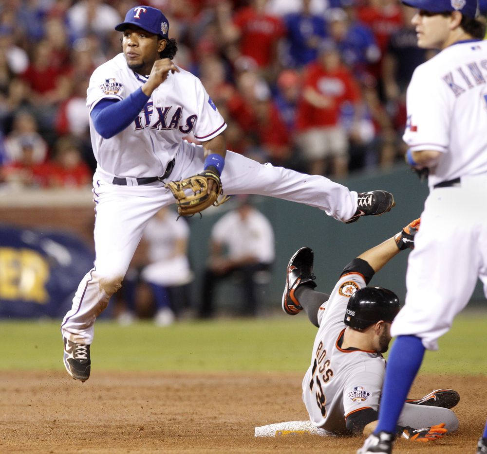 Texas Rangers shortstop Elvis Andrus forces San Francisco Giants Cody Ross out at second...