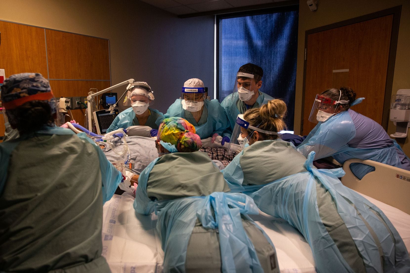 Samantha Rowley (far right) assists a team of caregivers, led by Dr. Catherine Chen (center), as they move a COVID-19 patient from one bed to another following his intubation at Parkland.