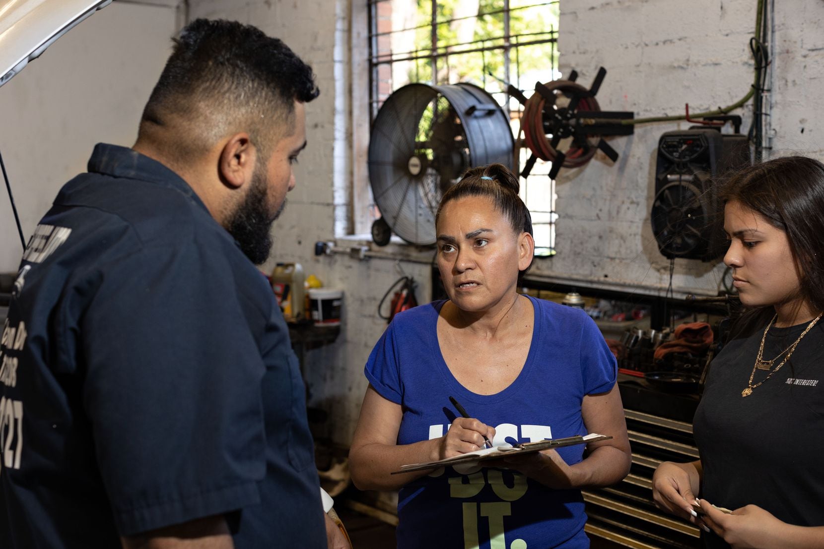 Gerardo "Jerry' Figueroa talks to Linda García and Maricela Urrutia as they sign the...