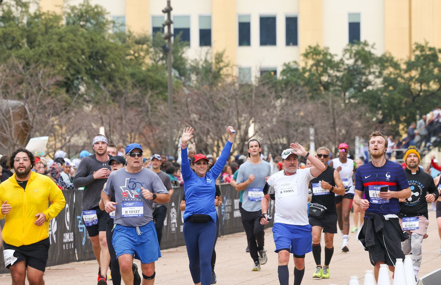 Half-marathon runners celebrate crossing the finish line at the BMW Dallas Marathon on...