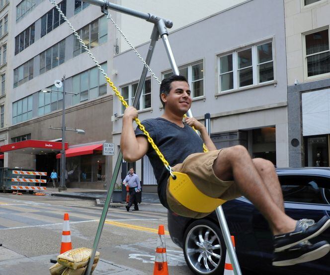 Patrick McDonnell swings on a swing-set at the annual Park(ing) Day in downtown Dallas.