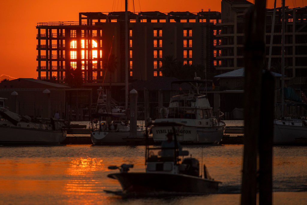 The rising sun shines through the skeletal remains of the Clines Landing condominium tower...