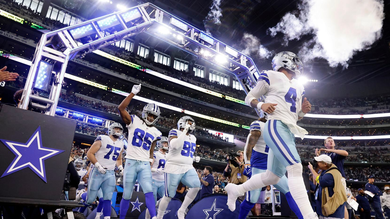 Dallas Cowboys quarterback Dak Prescott (4) and his teammates run onto the field to face the...